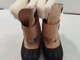une paire de bottes d'hiver pour enfants posée sur une surface blanche