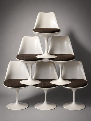 an image of a stack of tulip chairs with brown cushions