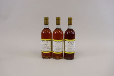trois bouteilles de vin posées les unes à côté des autres sur une surface blanche