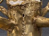 a gold statue of a woman holding a knife and fork