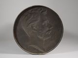 a close up of a metal plate with a woman ' s face on it