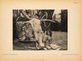 an old black and white photo of a woman sitting next to a goat