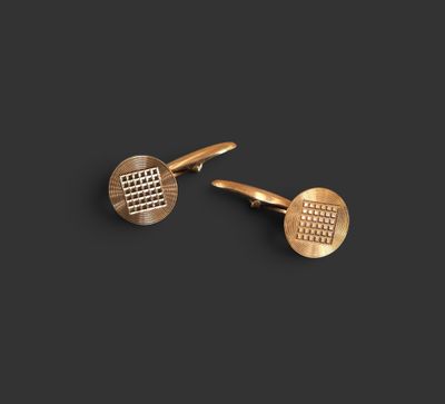 une paire de boutons de manchette en or sur fond noir