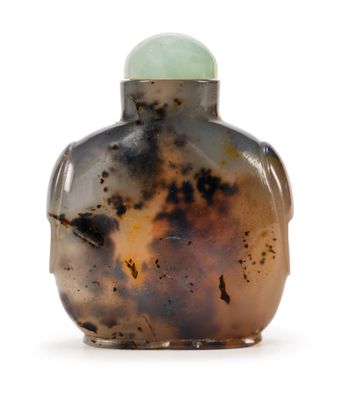 une petite bouteille en verre surmontée d'une boule verte