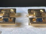 pair of gold tone cufflinks with blue stones on them