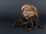 une tête en bois avec des dreadlocks sur fond noir