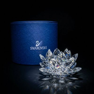 La fleur de cristal est posée sur la table, à côté d'une boîte bleue.