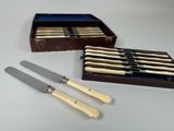 two knives and a box of knives are sitting on a table