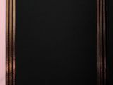 a picture of a black and gold frame on a pink wall