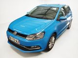 La Volkswagen Polo bleue est garée dans une pièce blanche.