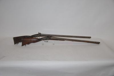 two guns are on a table with a white cloth