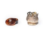two pieces of silver and a tortoise on a white surface