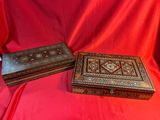 trois boîtes en bois posées sur une table recouverte d'un tissu rouge