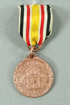 l'image d'une médaille entourée d'un ruban, posée sur une surface grise