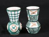 une paire de vases verts et blancs sur fond noir