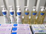 several bottles of hand sanitizer sitting on a table next to boxes of soap
