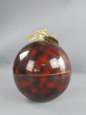 une pomme rouge surmontée d'une feuille d'or
