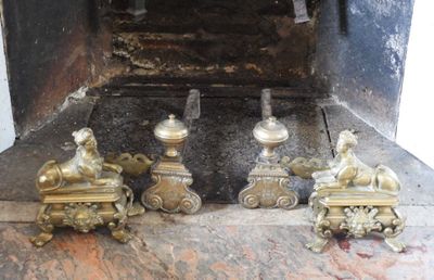 quatre figurines en laiton assises devant une cheminée