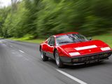 a red sports car driving down the road with trees in the background