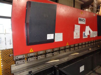 une grosse machine rouge qui se trouve dans un entrepôt