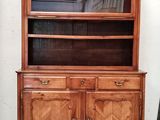 une armoire en bois surmontée d'un miroir, placée à côté d'une chaise