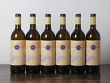 six bouteilles de vin sont alignées sur une table en bois