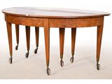 an oval dining table with casteors and a marble top