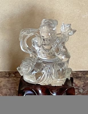 une statue en verre représentant une personne assise sur une table