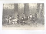 a black and white photo of a group of people with dogs