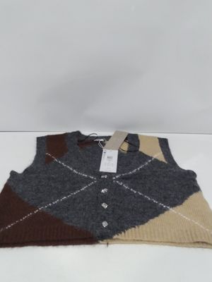 the vest is made of wool and has a brown, beige, and black argyle pattern