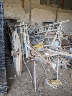 une charrette tirée par un cheval, immobilisée dans la poussière