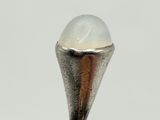 a close up of a silver ring with a white stone in it