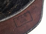 a close up of a brown leather bag with a tag on it