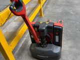 a machine that is sitting on the ground next to a yellow rail