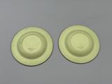 pair of yellow plates on grey surface with white background