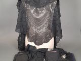 une photo d'un mannequin vêtu de vêtements et d'accessoires noirs, posé sur une table