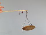 a person holding a wooden balance scale in their hand