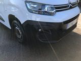 the white van is parked on the side of the road in the parking lot