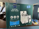 an electric deep fryer in the box on the counter