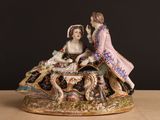 une figurine représentant une femme et un homme assis sur une table