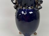 a blue vase with two handles on a stand