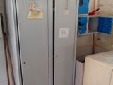 a refrigerator that is next to a stack of boxes in a room