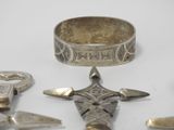 several silver metal items are arranged on a white surface