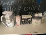 une table sur laquelle se trouvent un mixeur, un bol, une bouteille et d'autres objets