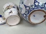 a blue and white vase and two cups on a table
