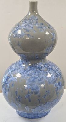 un vase bleu et blanc posé sur une table blanche
