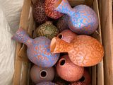 une boîte remplie de vases colorés posée sur une table