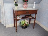 une petite table sur laquelle se trouve un vase de fleurs