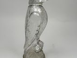 a glass figurine of a bird sitting on a base