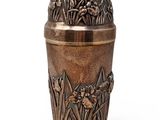 a metal vase with flowers on it on a white background